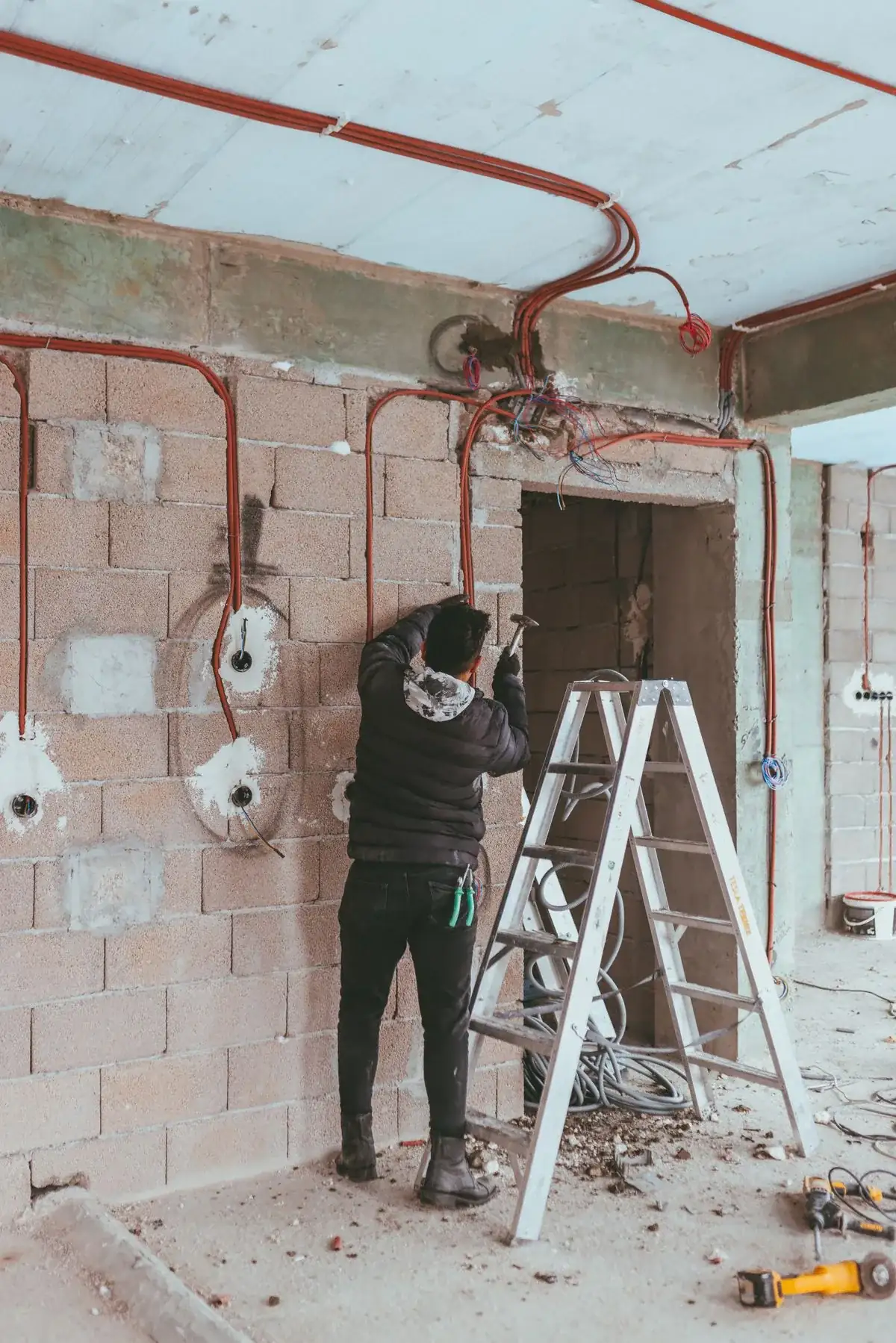 Electrician running new branch-circuit wiring on a job site